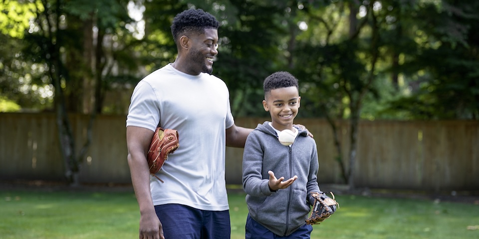 Father and son in backyard, baseball mitts